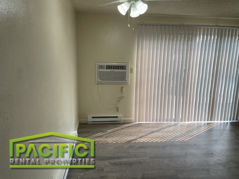 an empty living room with the air conditioner on the wall