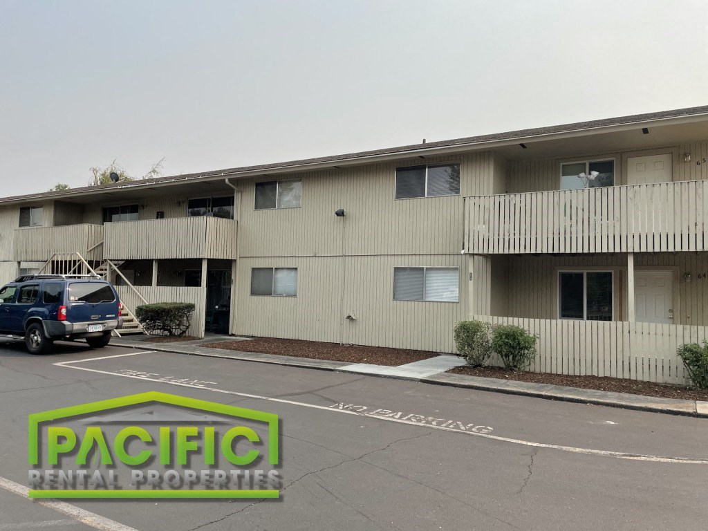 an apartment building with a van parked in a parking lot