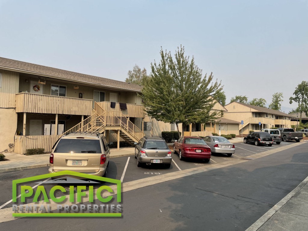 a parking lot with cars in front of an apartment building