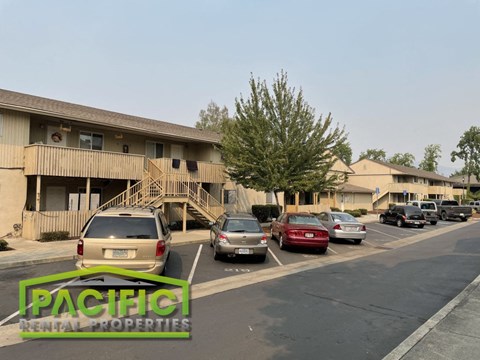 a parking lot with cars in front of an apartment building
