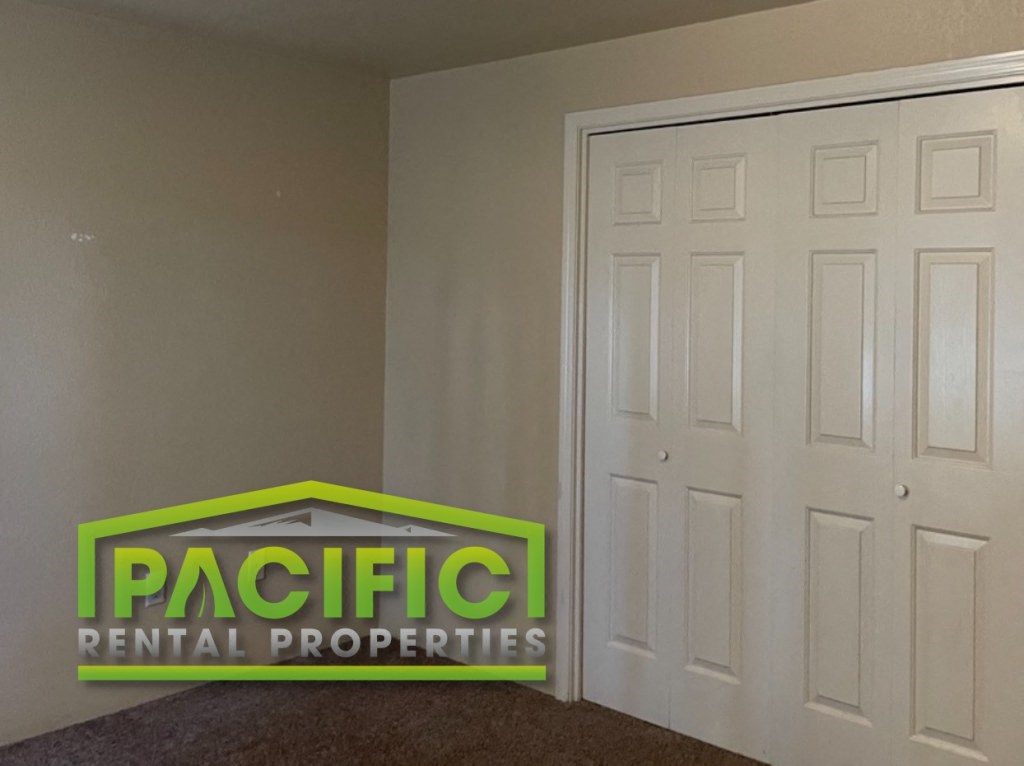 a room with two closets and a sign for pacific rental properties
