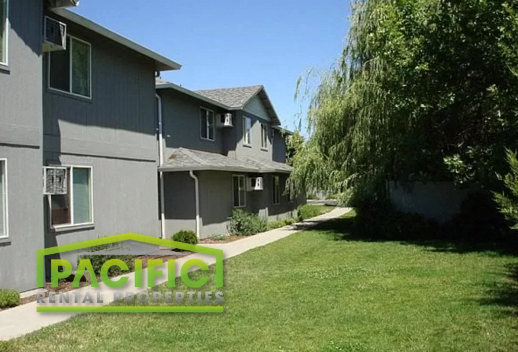 a green lawn in front of a gray house