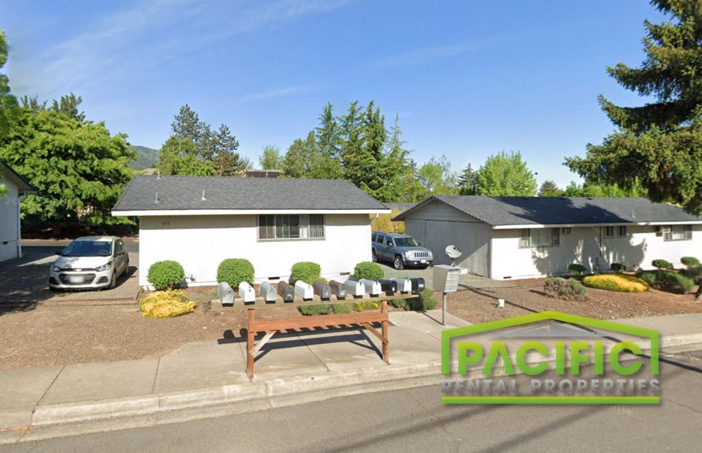 an aerial view of a yard with a picnic table in front of a house