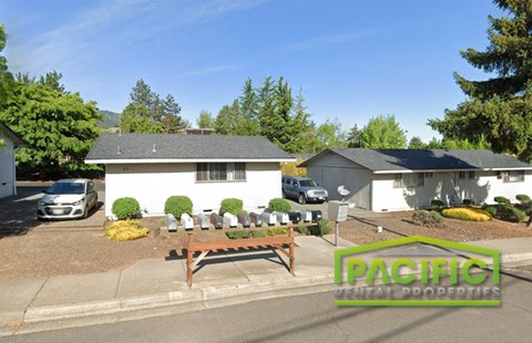 an aerial view of a yard with a picnic table in front of a house