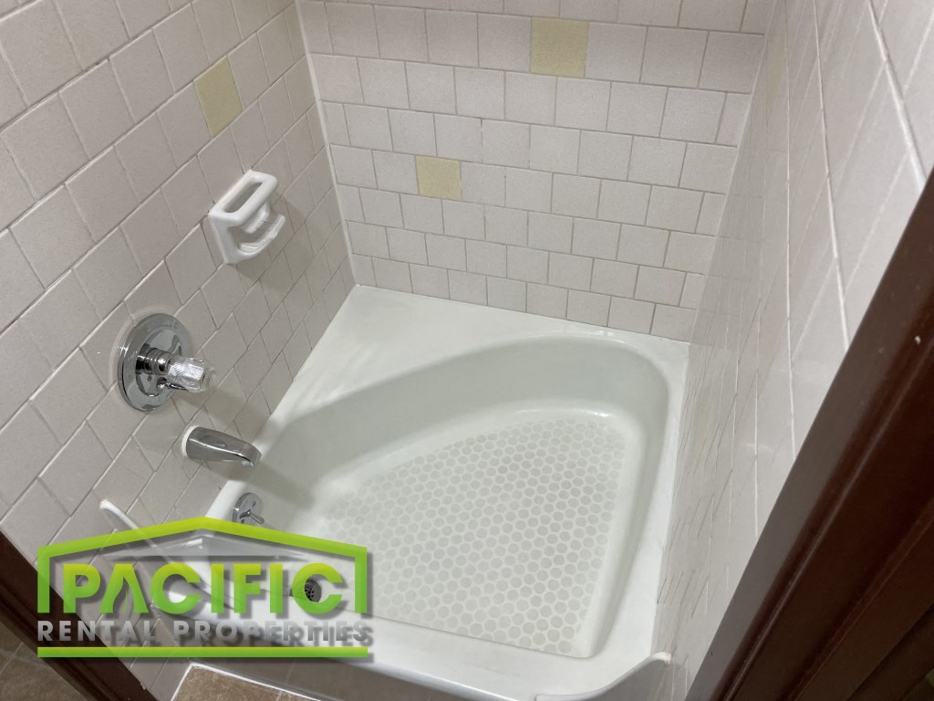 a small bathroom with a shower and a white tub