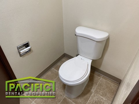 a bathroom with a toilet and a roll of toilet paper