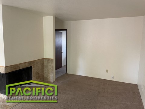 an empty living room with white walls and a fireplace
