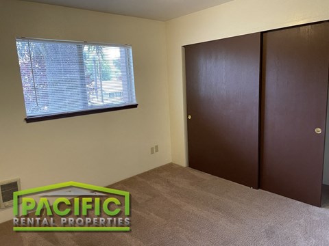 an empty room with a closet and a window