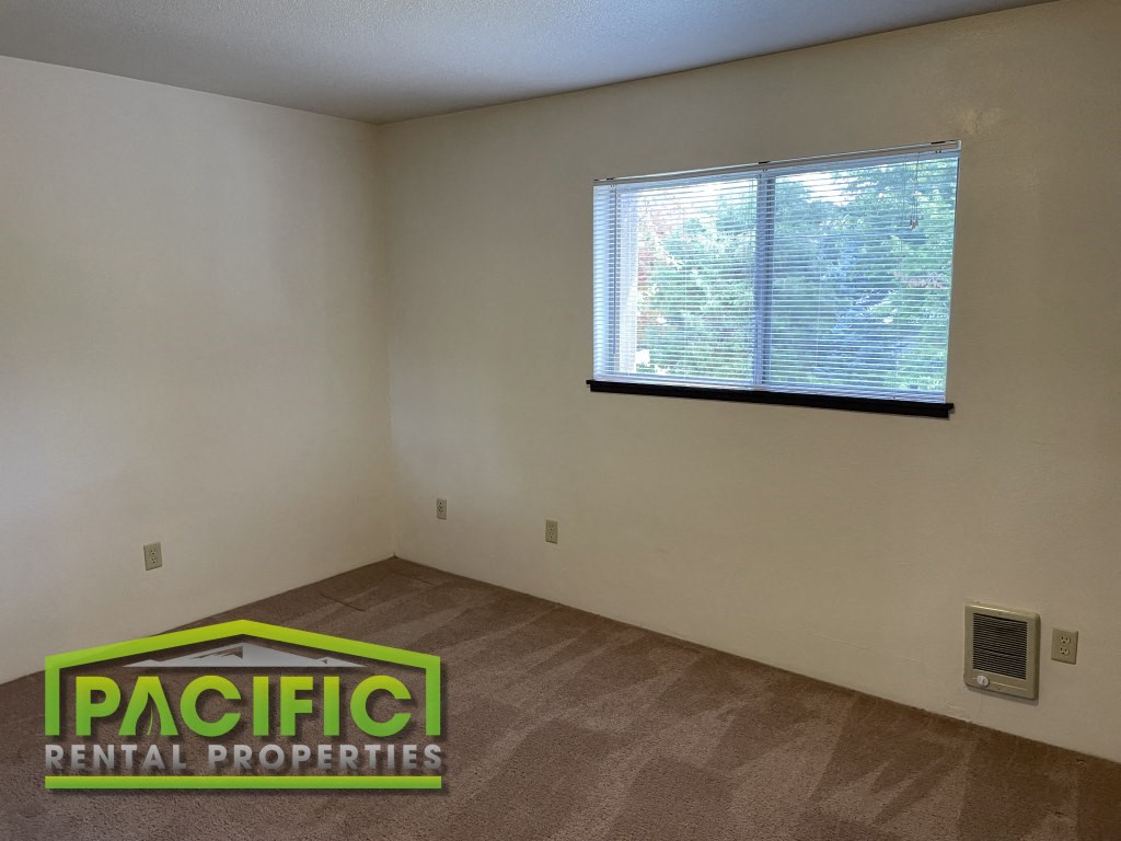 the interior of an empty living room with a window
