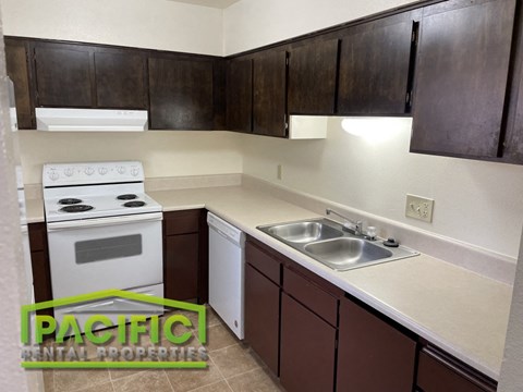 a small kitchen with white appliances and dark cabinets