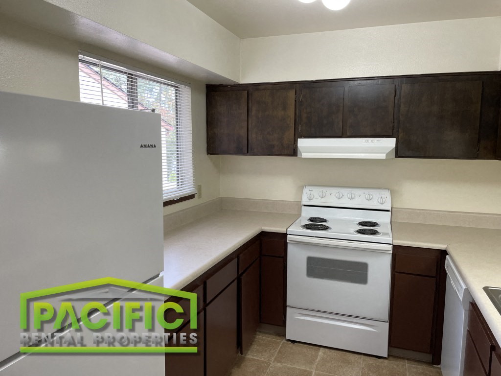 a kitchen with a white stove and a refrigerator