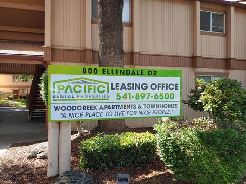 a sign for pacific leasing office in front of a building