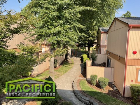 an aerial view of a pathway between two buildings and a tree