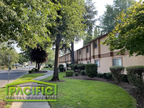 a building with trees and bushes in front of it