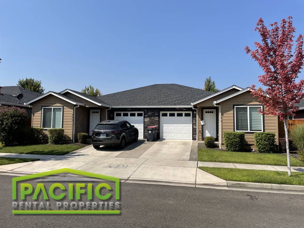 a suburban house with a car parked in the driveway