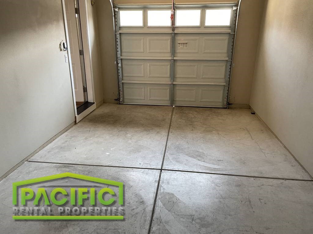 an empty garage with a tile floor and two garage doors