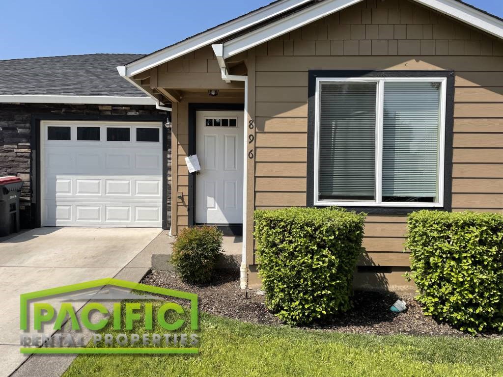 a tan house with a white garage door