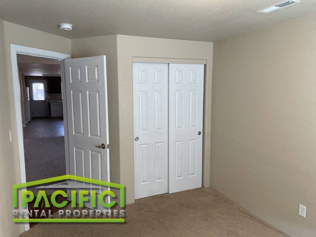 a room with two closets and a door and a carpeted floor