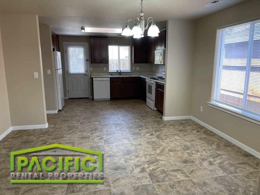 an empty kitchen and living room with tile flooring