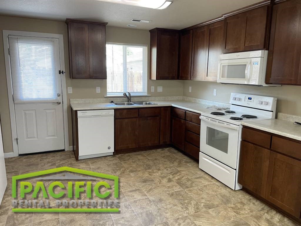 a kitchen with white appliances and brown cabinets