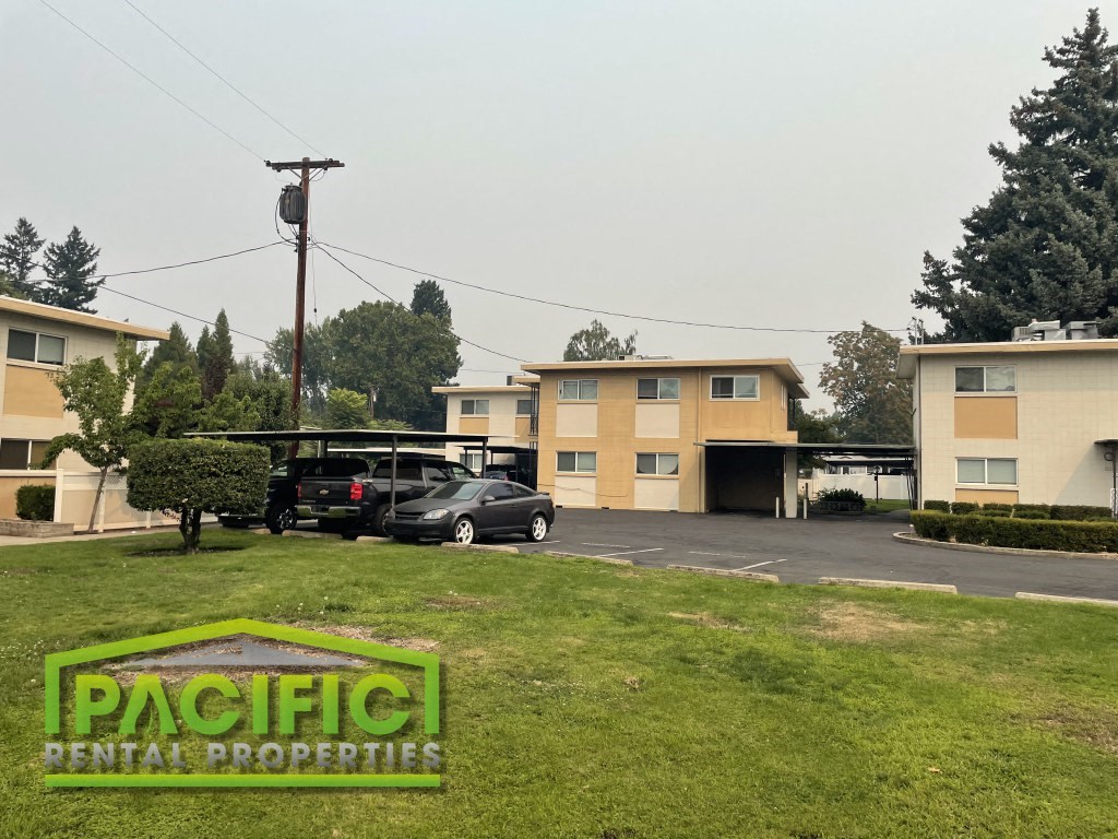 a parking lot with cars in front of some apartments