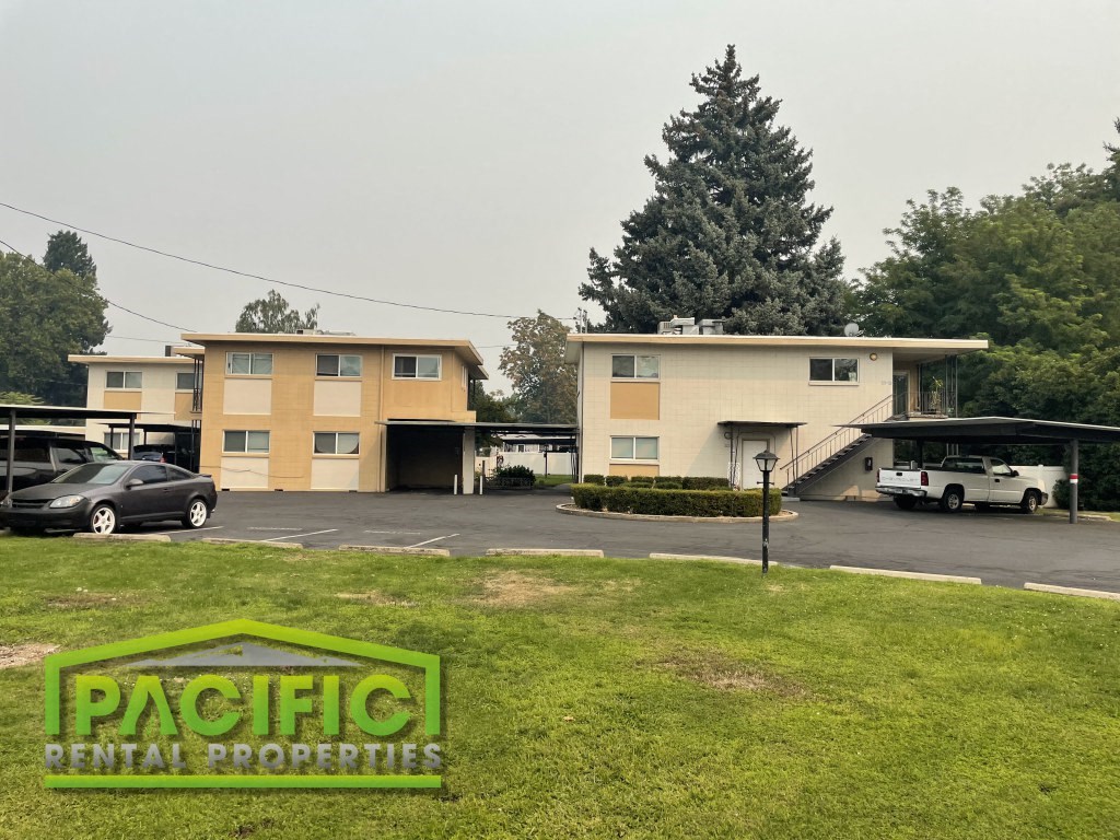 a building with a parking lot and cars in front of it