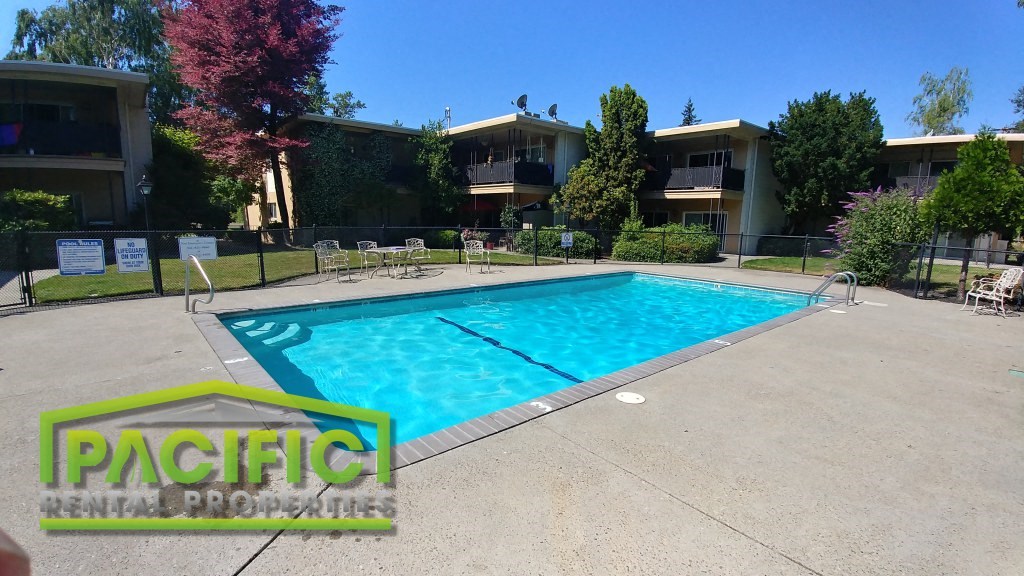 a resort style swimming pool in front of an apartment building