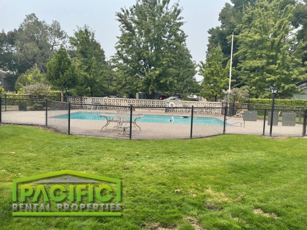 a tennis court with a fence around it and a swimming pool