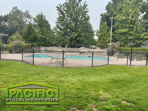 a tennis court with a fence around it and a swimming pool