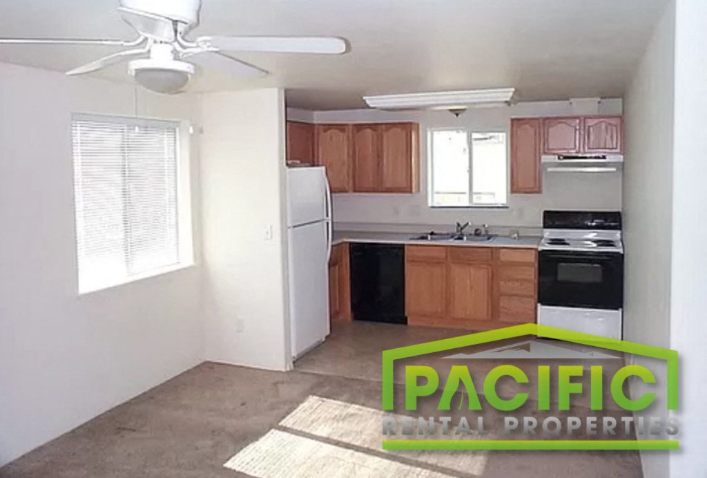 an empty kitchen with a ceiling fan and