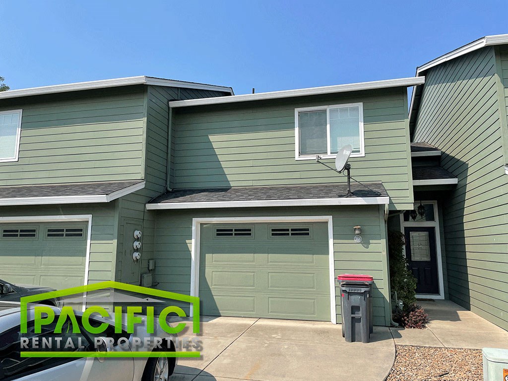 a green house with a green garage door