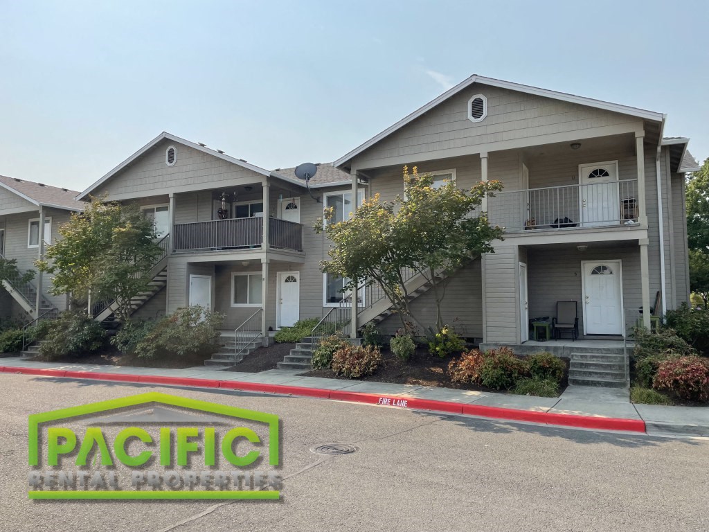 an apartment building with a parking lot in front of it