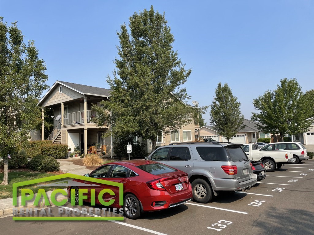 a parking lot filled with cars in front of a house
