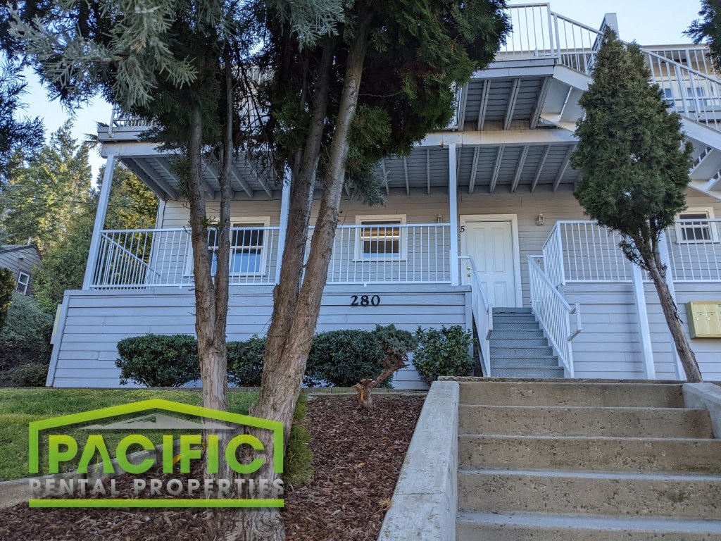 a building with stairs and trees in front of it