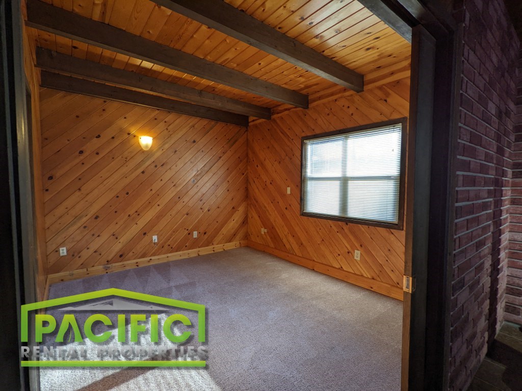 the interior of a cabin with wood walls and a concrete floor