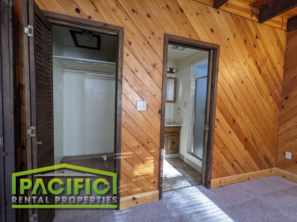 the interior of a wooden cabin with doors and a bathroom