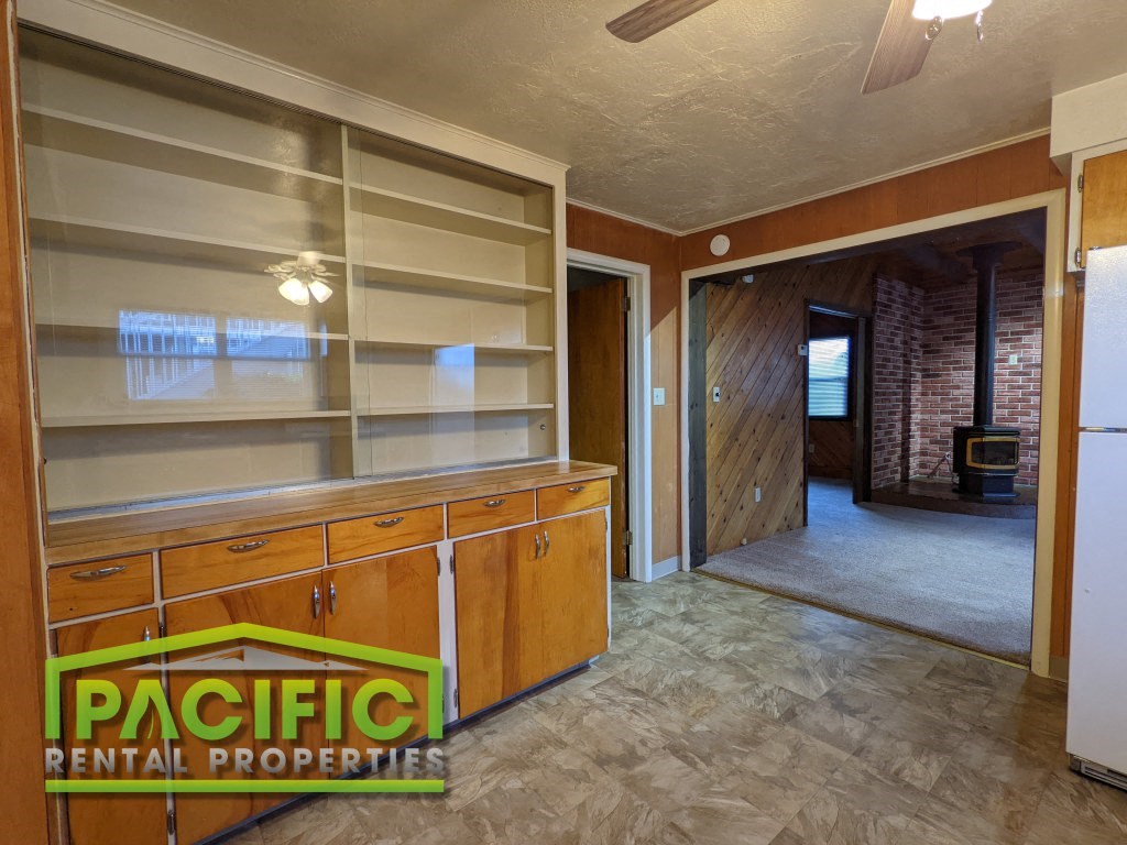 a remodeled kitchen with an empty pantry and a door to a hallway