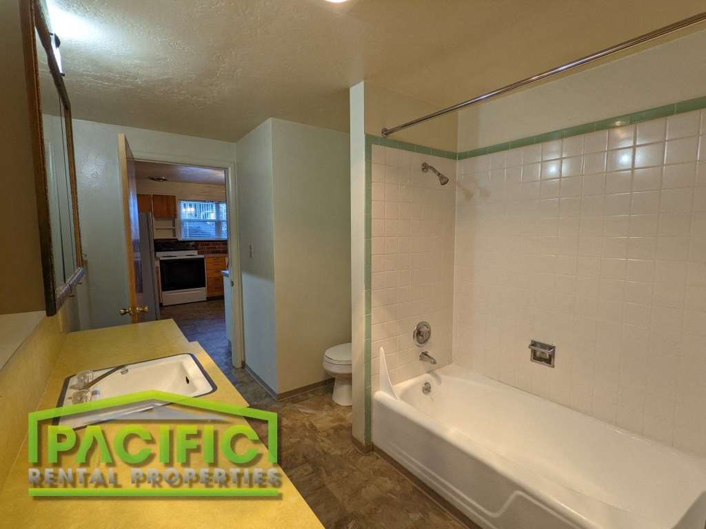 a bathroom with a tub and a sink and a toilet