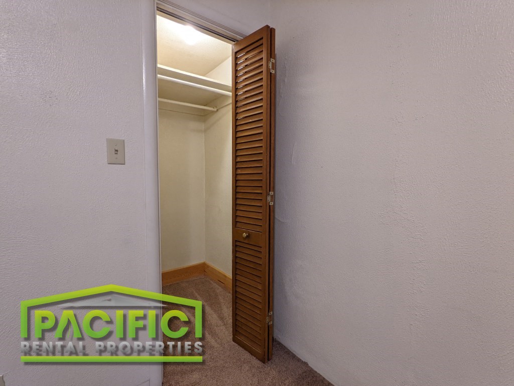 a bathroom with a wooden door and a white wall
