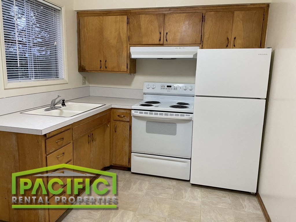 a kitchen with white appliances and wooden cabinets
