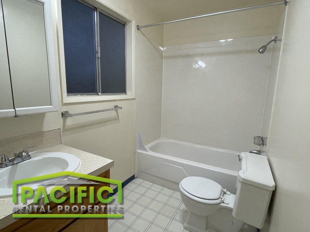 a bathroom with a toilet and a tub and a sink