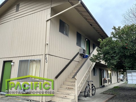 a building with stairs and two bikes in front of it