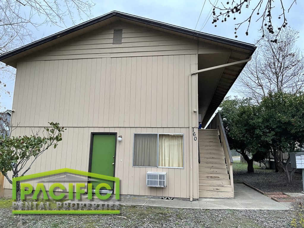 the front of a small house with a green door