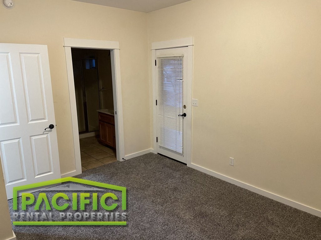 a room with a carpet and a door to a bathroom