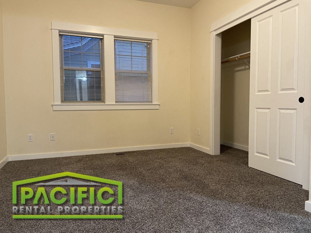 a room with a carpeted floor and a door to a closet