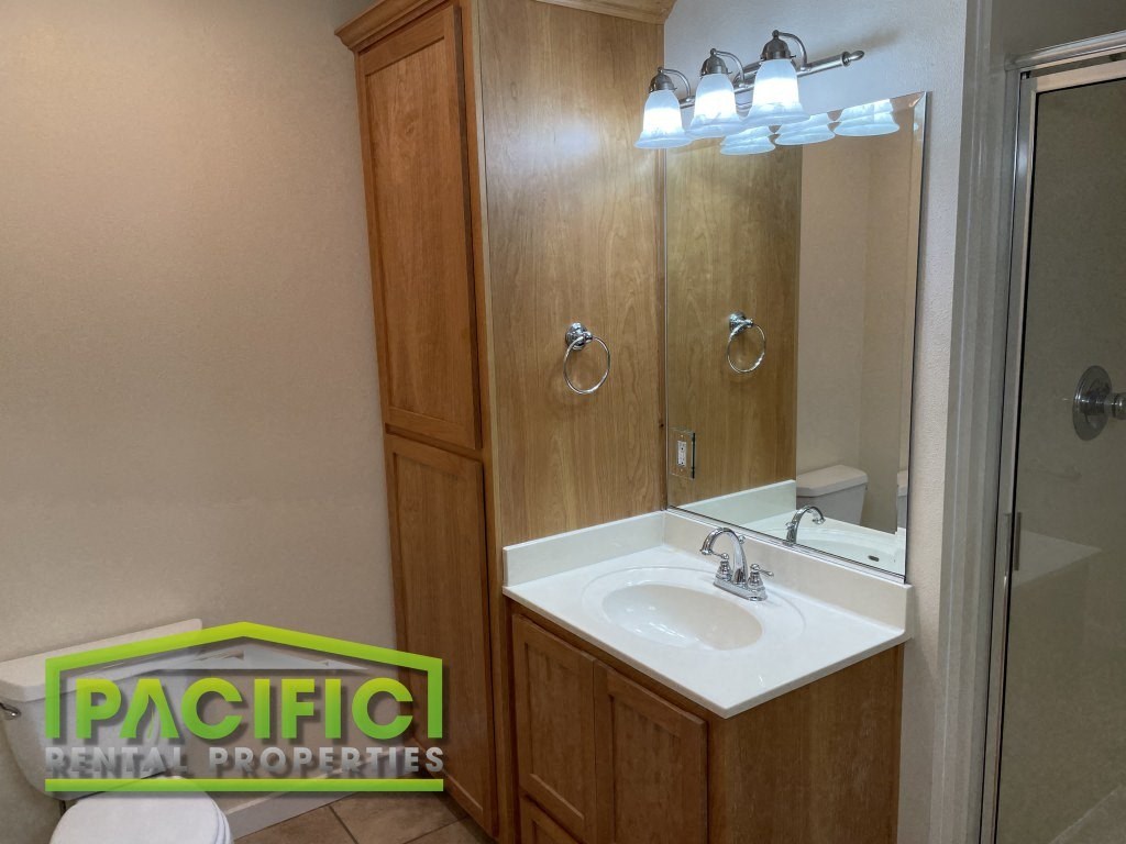 a small bathroom with a white sink and a shower