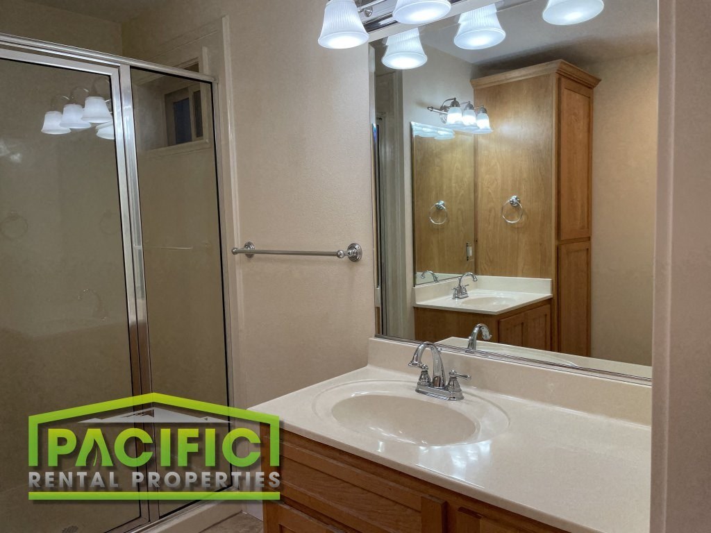 a bathroom with a sink and a shower and a mirror