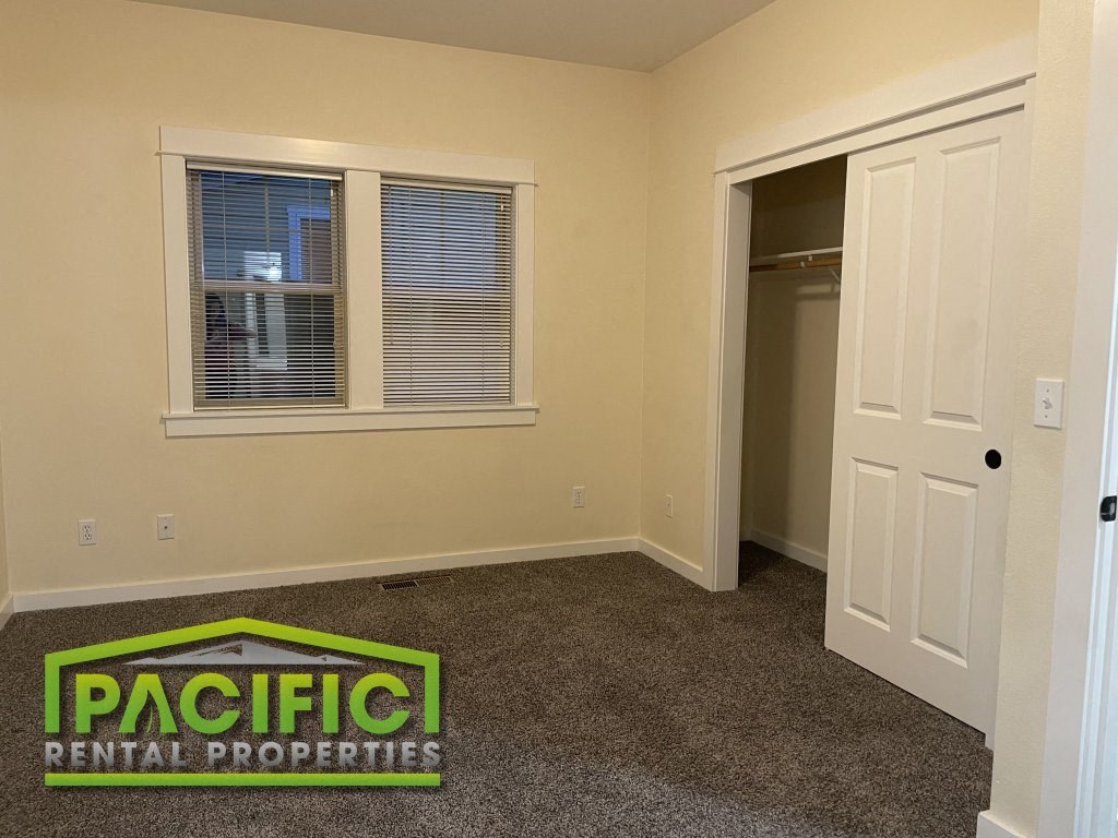 a bedroom with a closet and a door and a window