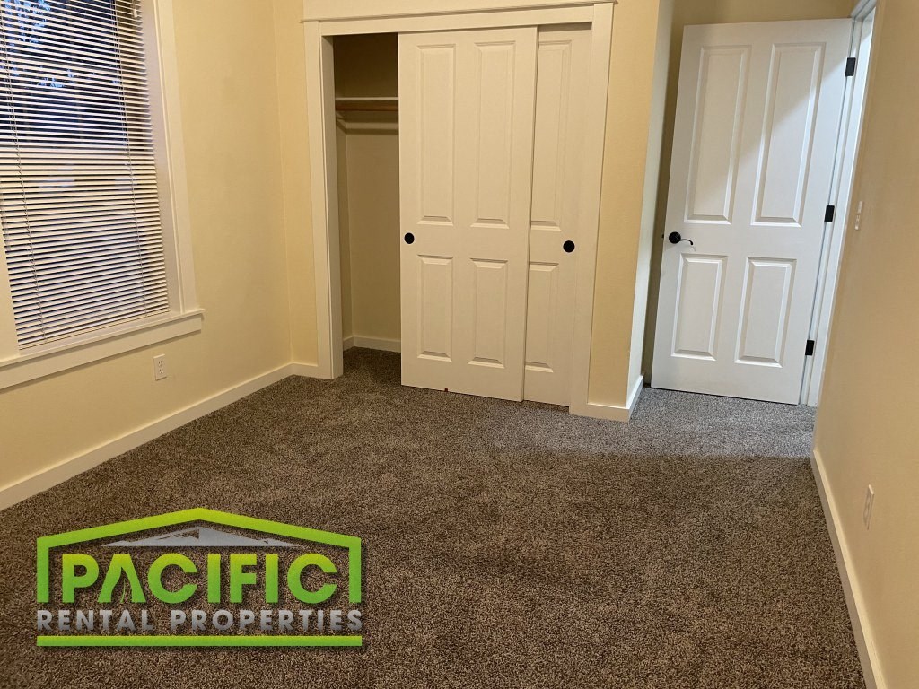 a carpeted room with a closet and a door