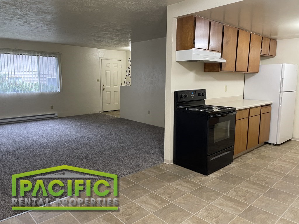 an empty kitchen with a stove and a refrigerator